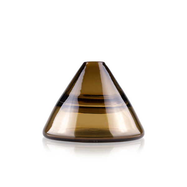 Featured is a conical amber glass vase with a broad base narrowing to a pointed top. The vase displays a glossy finish with a translucent quality, accentuated by a horizontal clear band that adds a touch of elegance. Its design combines modern aesthetics with classic glasswork, set against a reflective surface for added visual impact.