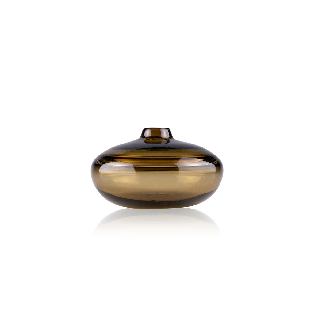 A sleek, amber-colored glass vase with a spherical body and a small, flat lid, featuring a glossy finish and a prominent horizontal stripe reflecting light. The vase's design combines modern aesthetic with classic elegance, set against a pure white background for a striking visual contrast.