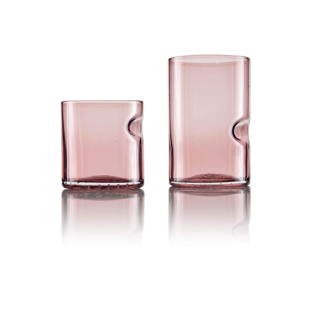 glass tumblers with an inventive thumb groove design; one short and the other tall, displayed side by side on a reflective surface, merging utility with a touch of elegance.