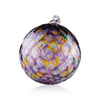 A decorative glass Christmas ornament with a mosaic of iridescent hues