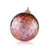 A decorative glass Christmas ornament with a mosaic of iridescent hues