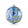 A glass Christmas orb featuring a vibrant collage of colors, reminiscent of a watercolor painting or oceanic scene, topped with a delicate glass loop for hanging, set against a white backdrop.