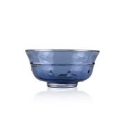 A classic deep glass bowl with a textured exterior and smooth rim, sitting on a clear base. The bowl's rich color and subtle design elements are highlighted against a pure white background, exemplifying timeless glass craftsmanship.