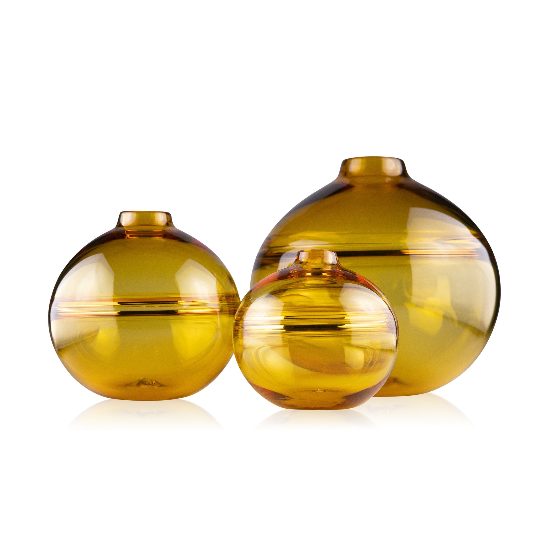 Round-bottomed halo glass vases in varying sizes, each with a small opening at the top, creating a harmonious arrangement of translucent, warm-toned spheres on a reflective surface