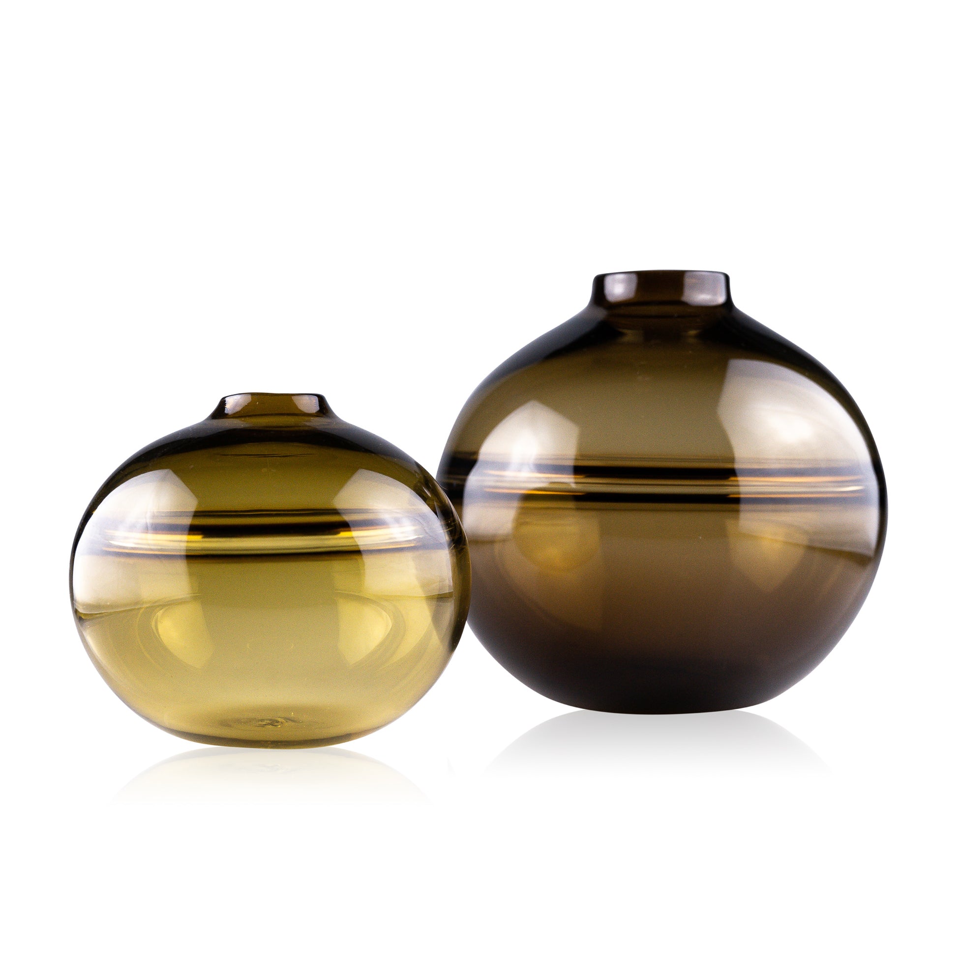 Round-bottomed halo glass vases in varying sizes, each with a small opening at the top, creating a harmonious arrangement of translucent, warm-toned spheres on a reflective surface