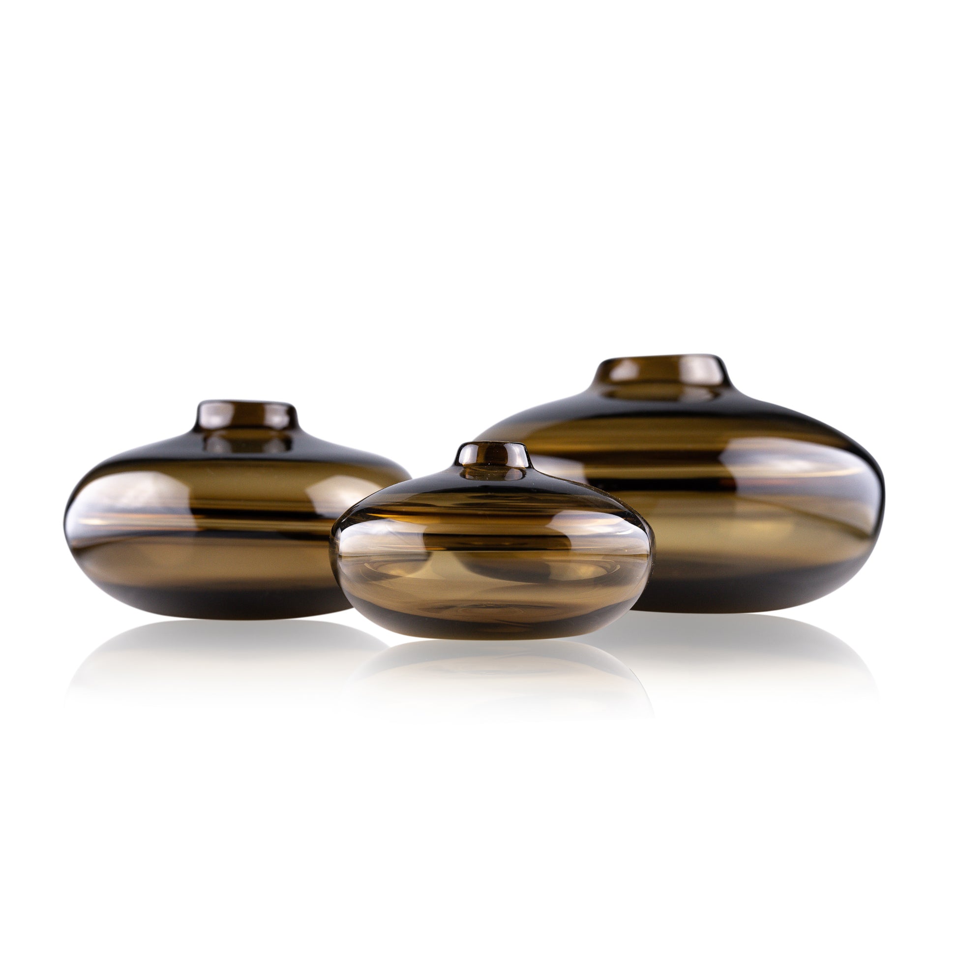 A squat glass vessel with a wide, flattened body and a narrow, raised lid, photographed against a white background, showcasing its smooth lines and tranquil, translucent color, reflective of serene, contemporary glass artistry.