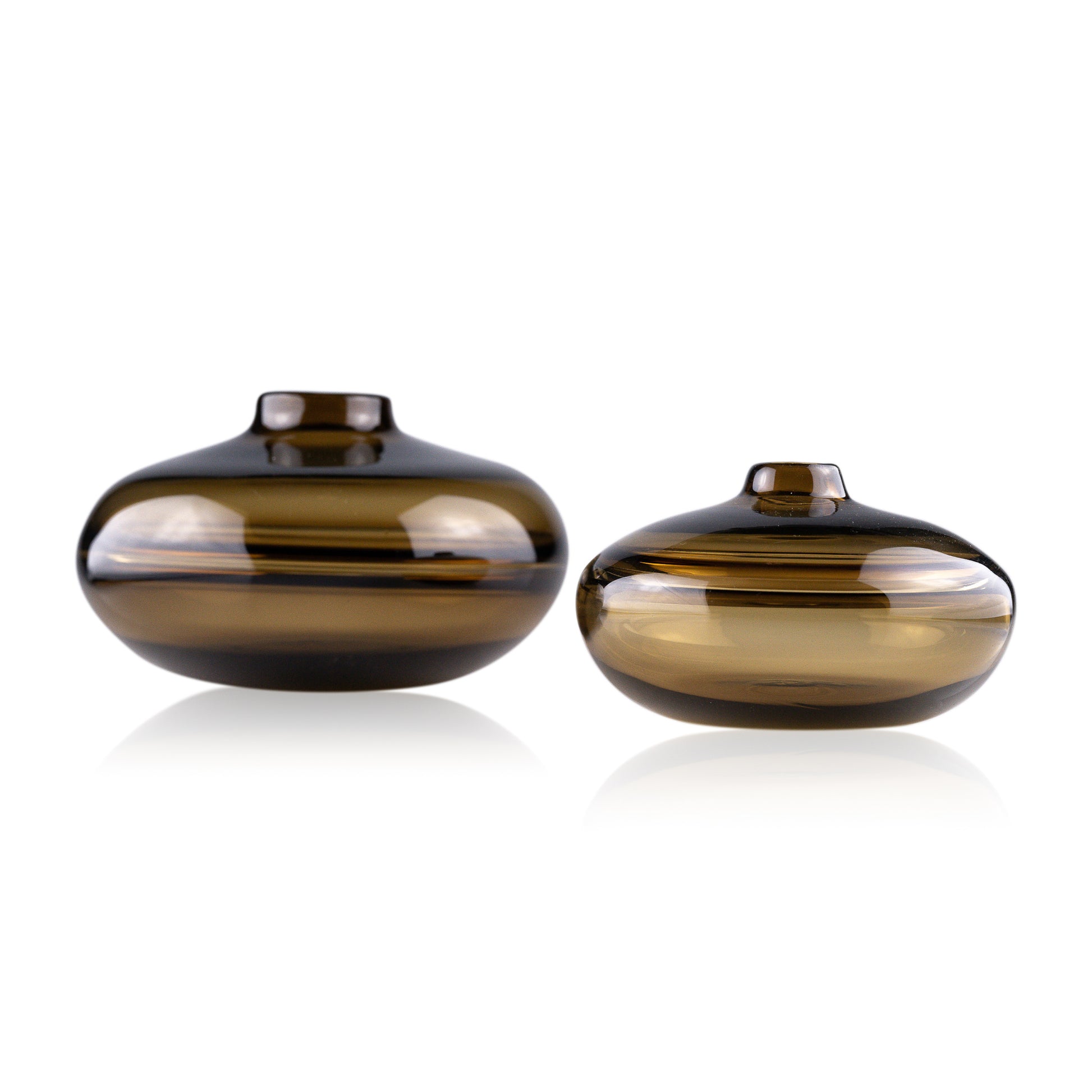 A squat glass vessel with a wide, flattened body and a narrow, raised lid, photographed against a white background, showcasing its smooth lines and tranquil, translucent color, reflective of serene, contemporary glass artistry.