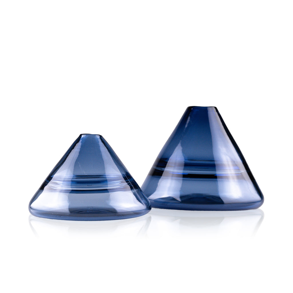 Unconventional halo vase with a conical shape, arranged in a staggered formation and reflected on a glossy surface, highlighting their sleek and contemporary design.