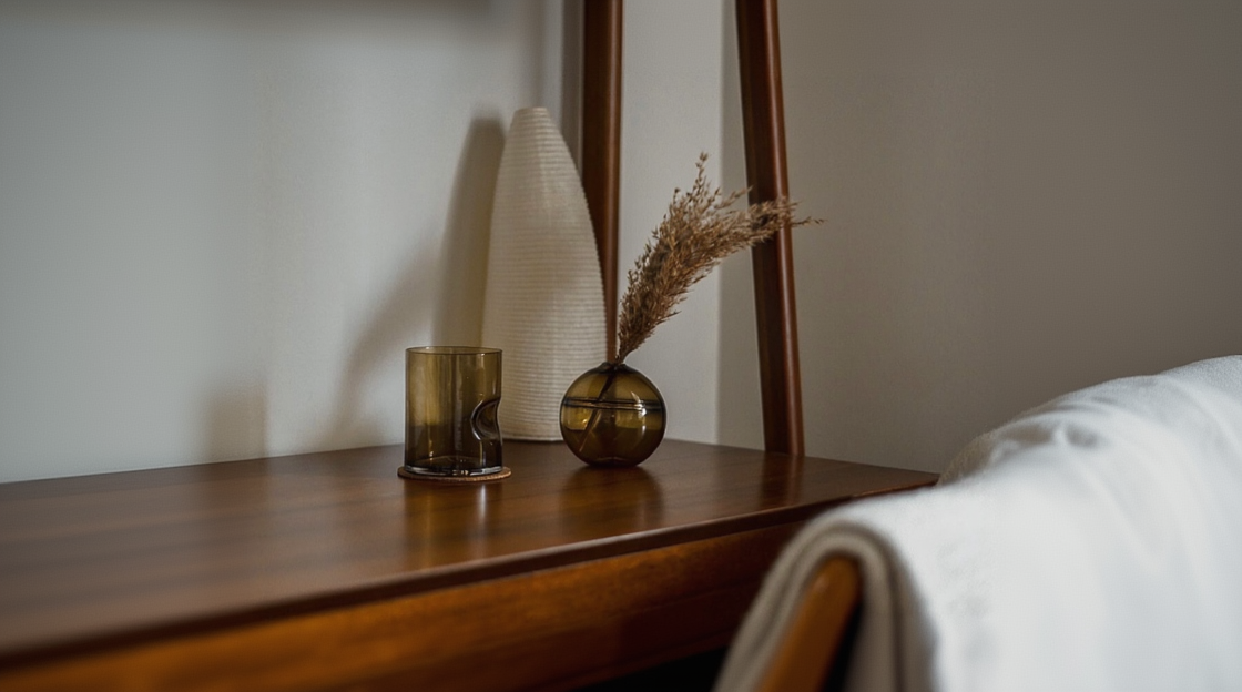 Round-bottomed halo glass vases in varying sizes, each with a small opening at the top, creating a harmonious arrangement of translucent, warm-toned spheres on a reflective surface